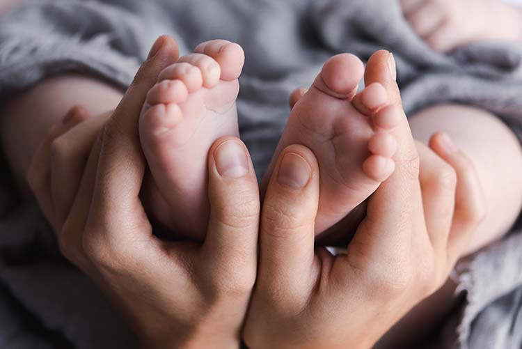 Babyfüßchen Zwei Hände umgreifen zwei Babyfüßchen